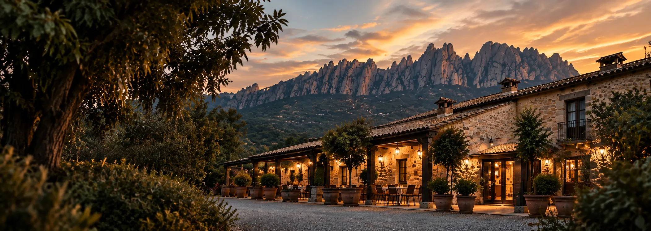 Entrada de piedra iluminada de noche, con el rótulo Restaurant en el muro y un arco que da paso al patio