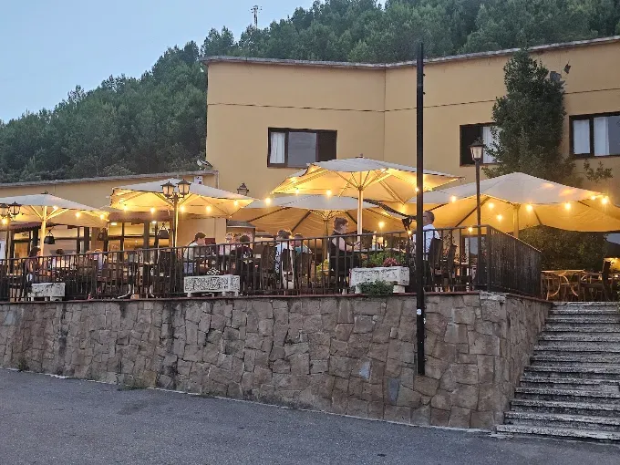 Terraza de Els Torrents al atardecer, con sombrillas y luces sobre el muro de piedra